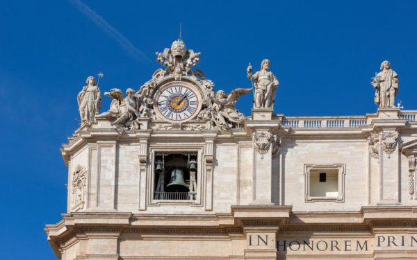 Facade of Saint Peter's Basilica with Bell Gate on a background of blue sky