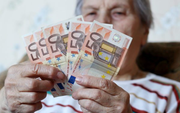 elederly woman counts Euro notes