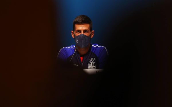 Novak Djokovic of Serbia wears a protective face mask during the press conference
