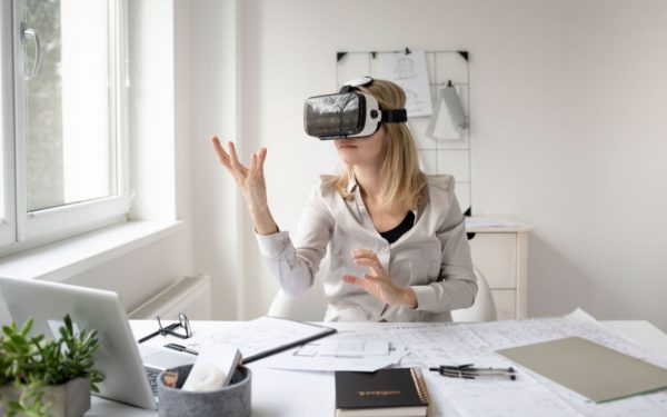 Young woman with virtual reality goggles in her office