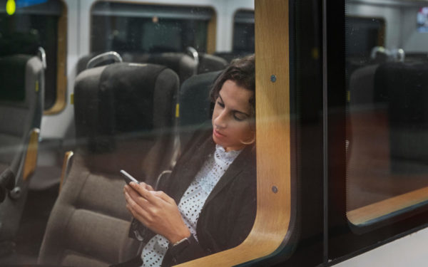 Woman using smart phone on train cyberflashing