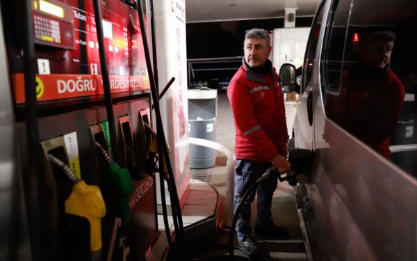 man filling up car at petrol station, amid rising oil and gas prices