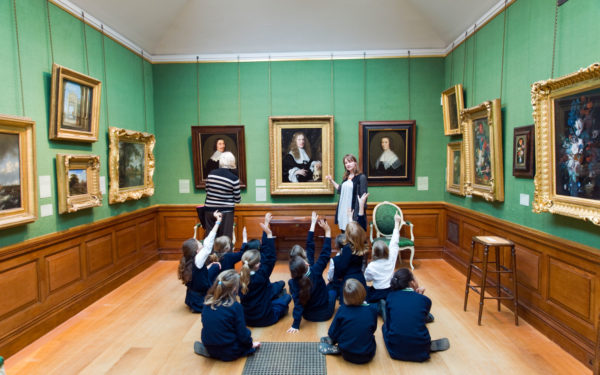 School children raising their hands on educational school trip to The Dulwich Picture Gallery, London, England, UK