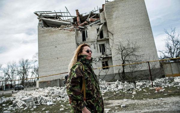 Mariupol, Ukraine: In the front line village of Lebedinske a female fighter walks by a building destroyed by separatist rebels. Despite a ceasfire deal signed in Minsk in mid-February, fighting continues at a few strategic points along the front line. One key area is around the steel-making port city of Mariupol, which is seen as a target for pro-Russian and pro Putinseparatists.