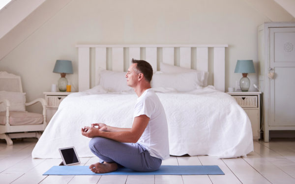 Mature Man With Digital Tablet Using Meditation App In Bedroom for mental health