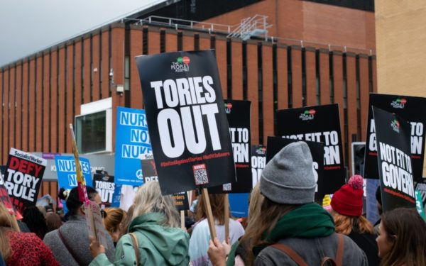 Manchester UK. October 3, 2021. Tory Party Conference protest, Oxford Road. Protesters in front of Kilburn building with placard text Tories Out
