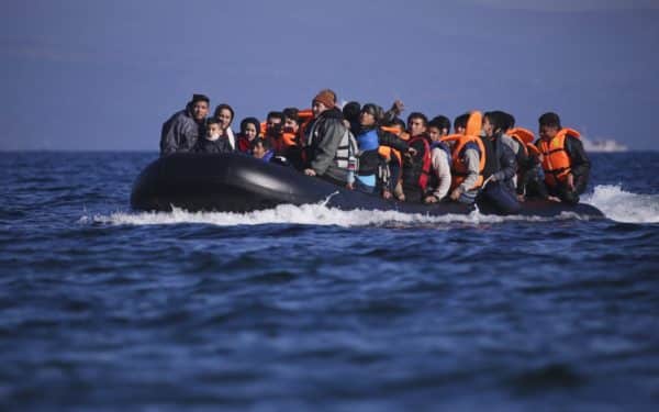 Lesbos island, Greece, November 13, 2015: Grroups of Refugees and Migrants aboard dinghies reach the Greek Island of Lesvos after crossing the cold Aegean sea from Turkey arriving thirsty