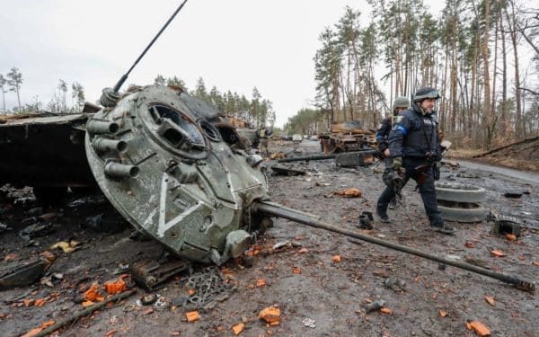 April 2, 2022, Zhytomyr Region, Ukraine: Ukrainian police officers walking past near the wreckage of Russian tanks at a village near the Zhytomyr region, about 4-5 kilometres from Irpin, following Ukrainian counter-attacks on Russian forces. The city of Irpin and areas around are said to have be retaken by the Ukrainian forces