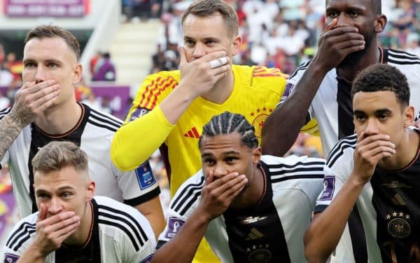 German football players make a gesture to show they have been gagged by FIFA during 2022 World Cup in Qatar.