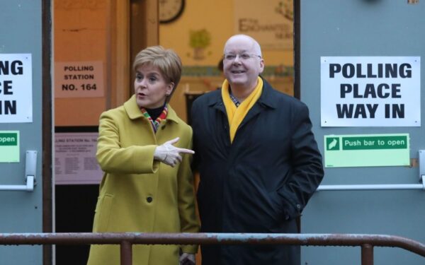 Scottish First Minister Nicola Sturgeon poses for the media with husband Peter Murrell, outside polling station in Glasgow, Scotland, on Dec. 12, 2019.