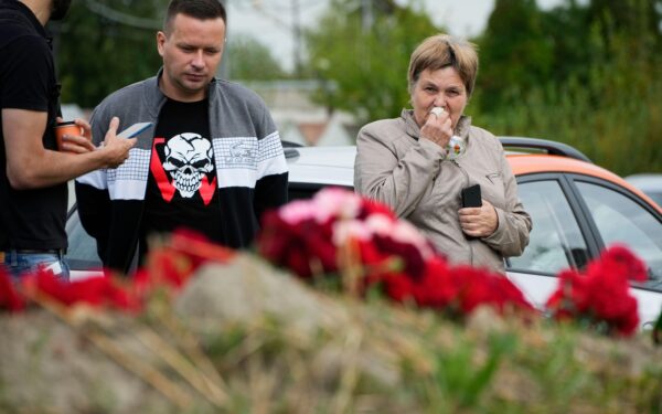 A woman reacts at an informal memorial next to the former 'PMC Wagner Centre' in St. Petersburg, Russia, Thursday, Aug. 24, 2023.
