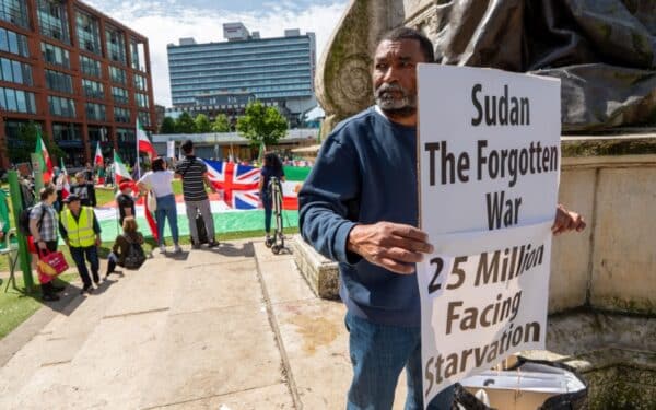 Man with a Sudan war protest banner joins pro-Palestine protest in Manchester, UK (via Gary Roberts/ Alamy)