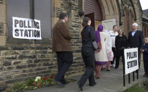 Voters enter polling station in West Yorkshire - in UK where First Past the Post voting system exists