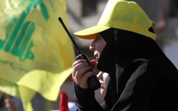 A Hezbollah security woman speaks on her radio during a rally marking the anniversary of the 2006 Israel-Hezbollah war (Associated Press via Alamy)