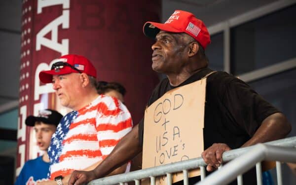 Donald Trump supporters holding a "God + USA loves Trump" sign at a rally in Philadelphia, Pennsylvania (Ana Kapustina via Shutterstock)