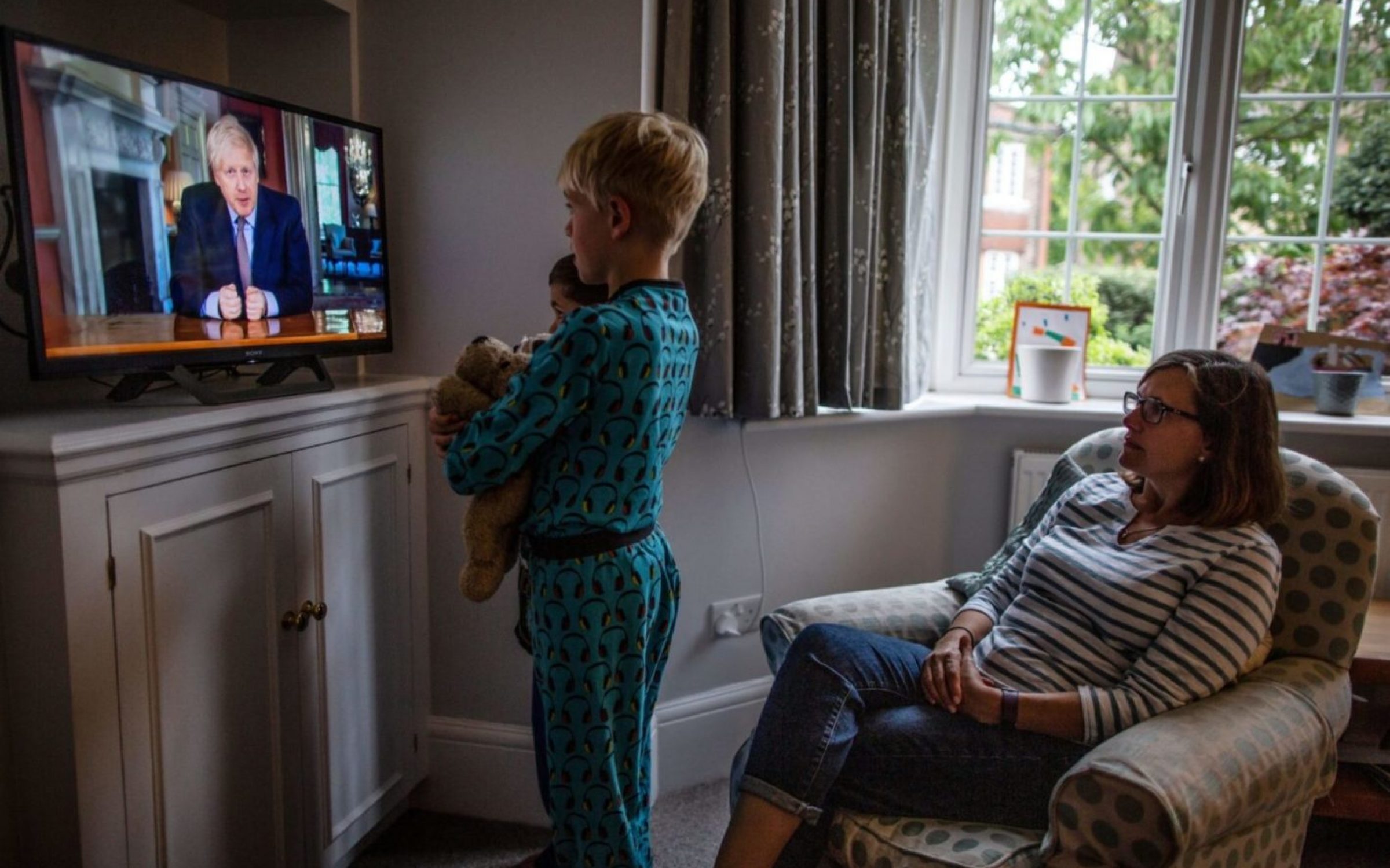 Family watches Prime Minister Boris Johnson address the UK nation on national television setting out steps of a 'Road map' out of Coronavirus lockdown