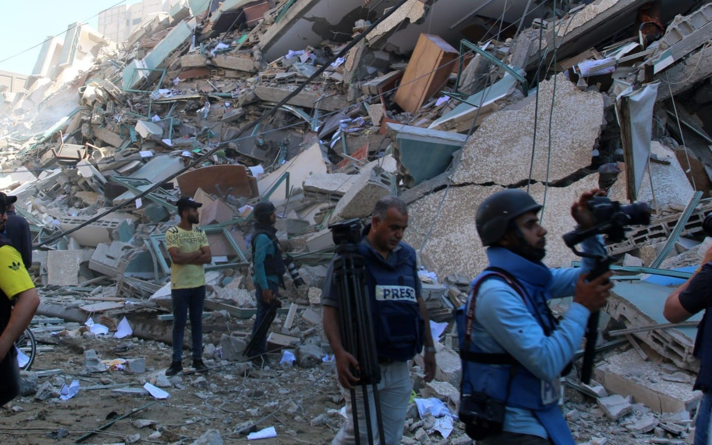 Gaza, Gaza. 15th May, 2021. Journalists walk on the rubble of Jala Tower, which was housing international press offices, following an Israeli airstrike in the Gaza city on Saturday, May 15, 2021 in Gaza City. The attack came roughly an hour after the Israeli military ordered people to evacuate the building, which also housed Al-Jazeera and a number of offices and apartments. There was no immediate explanation for why the building was targeted.