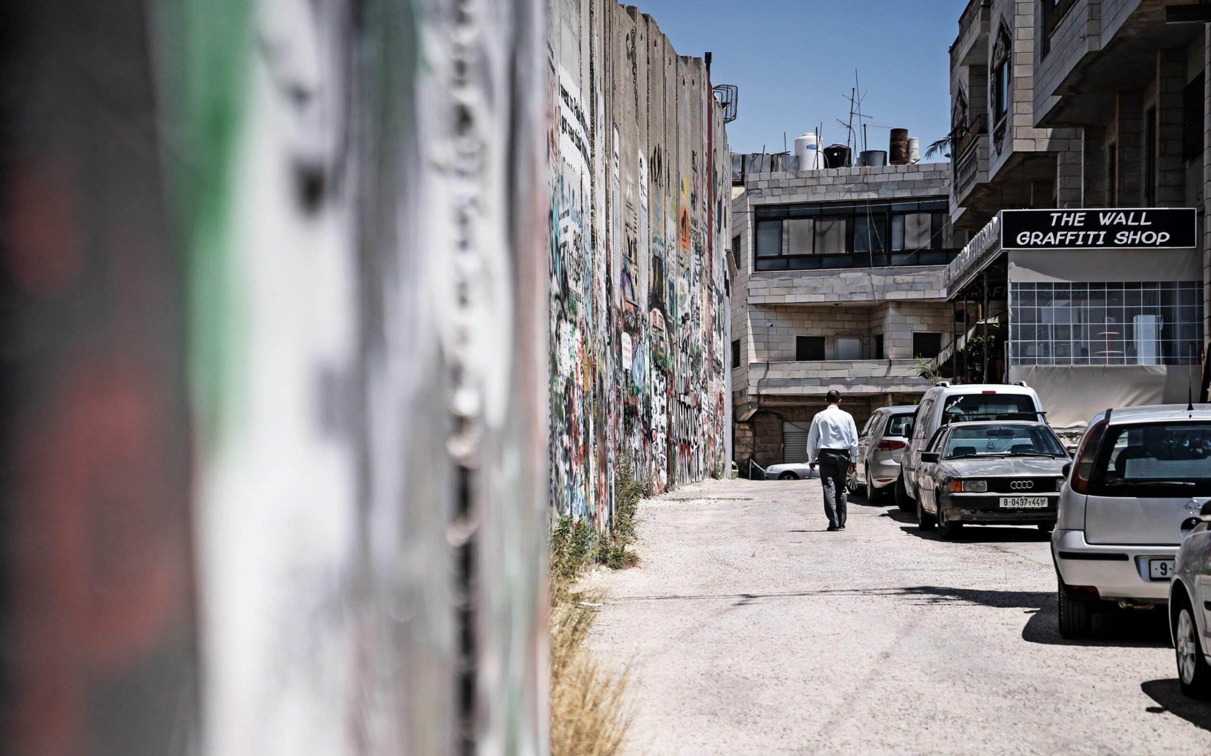 A view of a man walking in the street along the border between Israel and Palestine. Credit: Wirestock, Inc. / Alamy Stock Photo