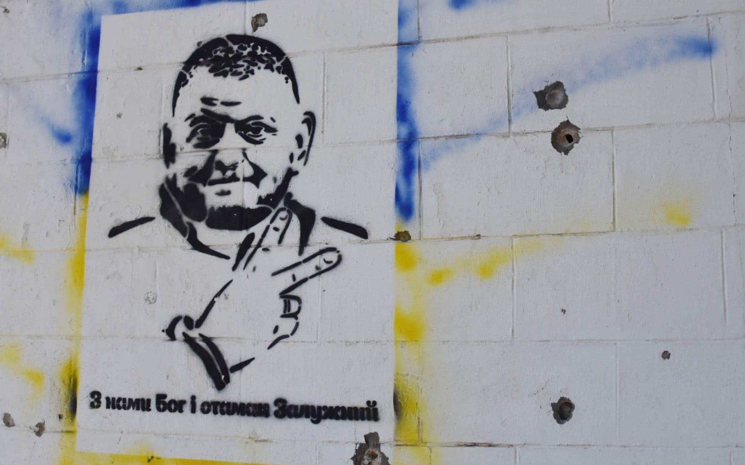 Graffiti depicting General Valery Zaluzhnyy, head of Ukraine's armed forces and writing “God is with us and commander Zaluzhny” on a wall damaged by Russian shelling in Huliaipole, Ukraine (via SOPA/Alamy)