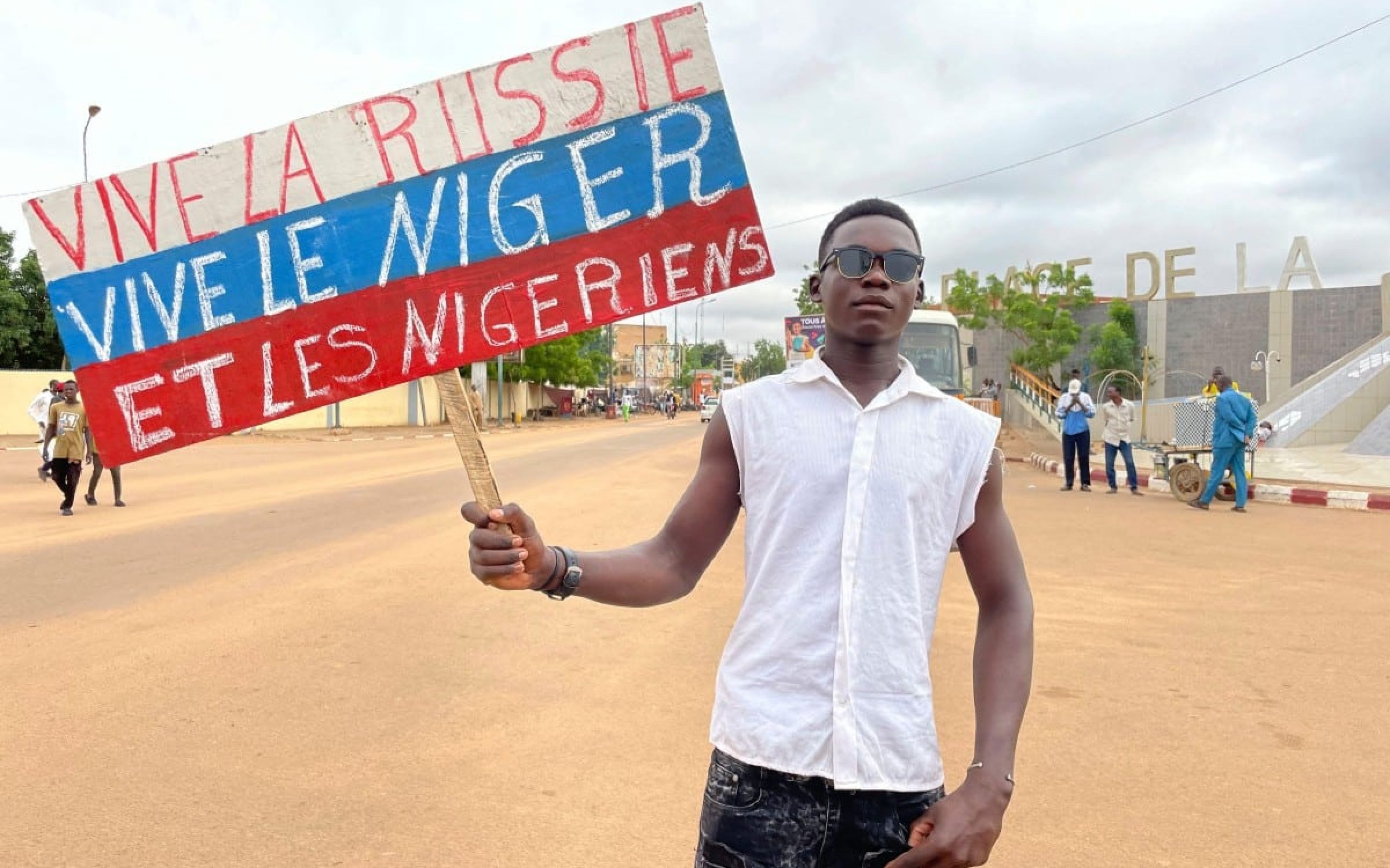 A supporter of Niger's ruling junta holds a placard in the colors of the Russian flag reading "Long Live Russia, Long Live Niger and Nigeriens" in Niamey, Niger (via AP/Alamy). Demonstrating growing influence of Russia in the Sahel region