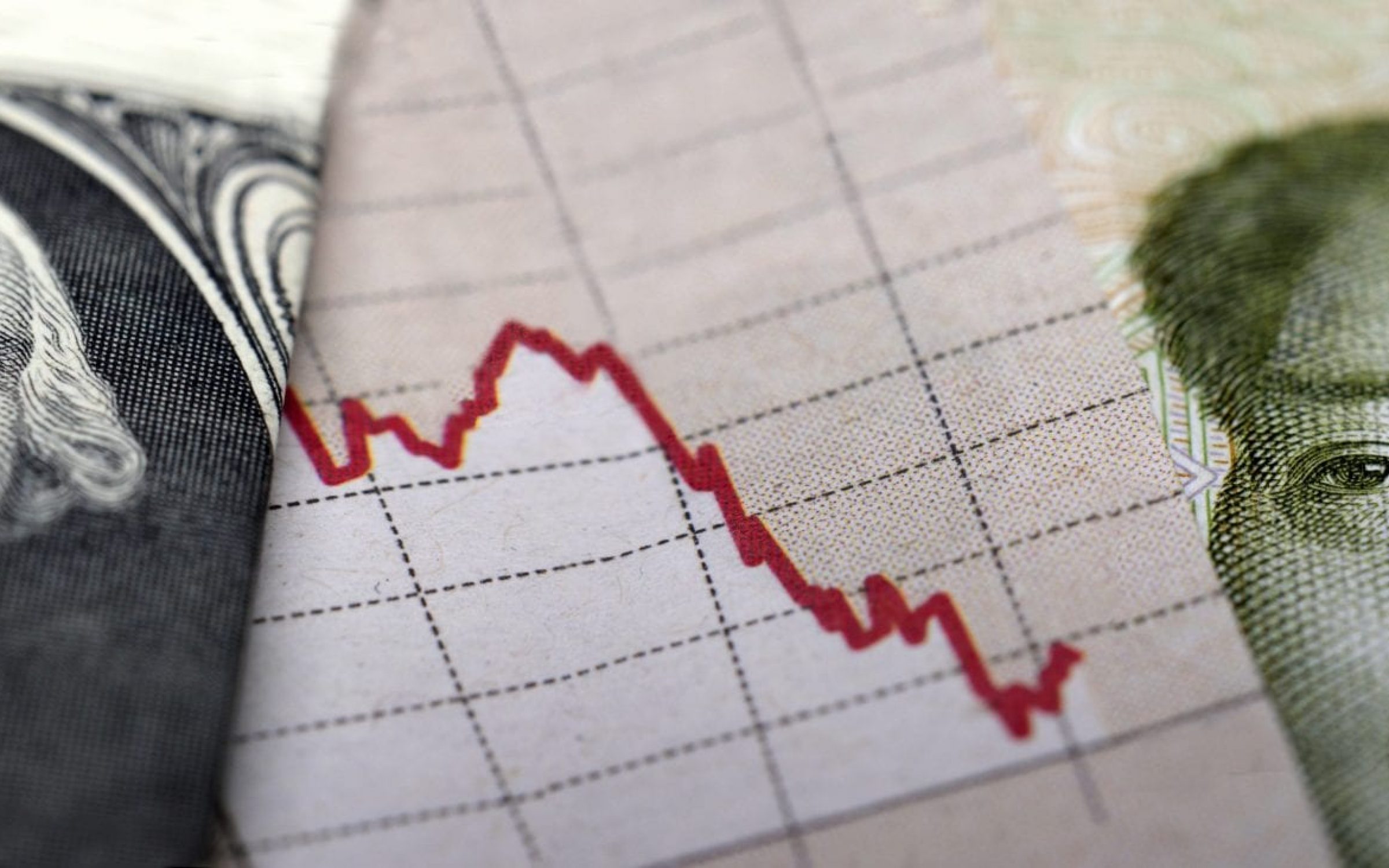 Stock Market Graph next to a 1 dollar bill (showing former president Washington) and a Chinese banknote (showing Mao). Red trend line indicates the stock market recession