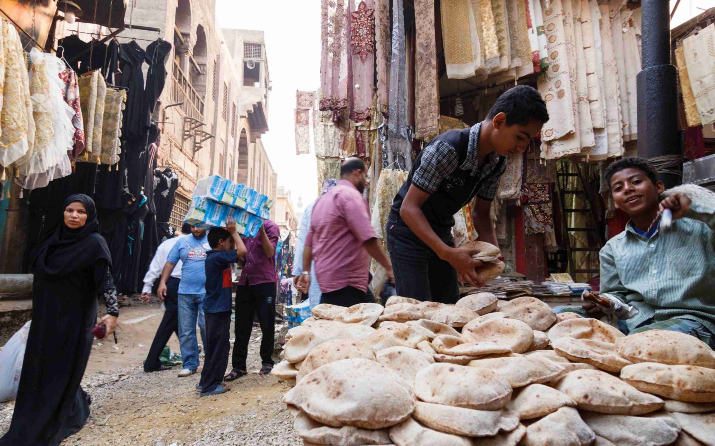 Bazaar street scene with child selling bread. Islamic Cairo, Egypt