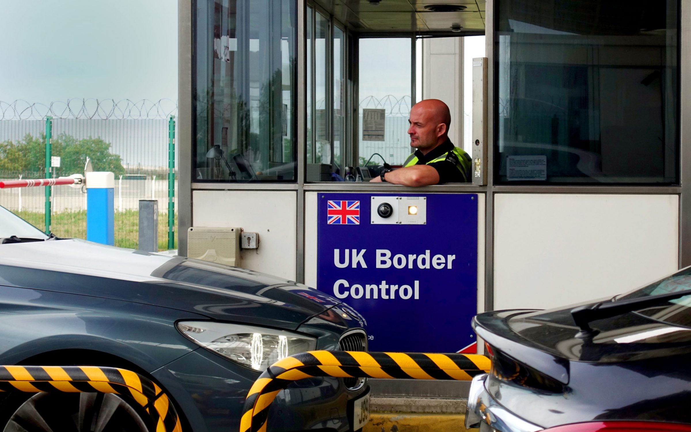Calais, France - August 12 2018: Member of the UK Border Force police checking cars as they approach the Eurotunnel terminal
