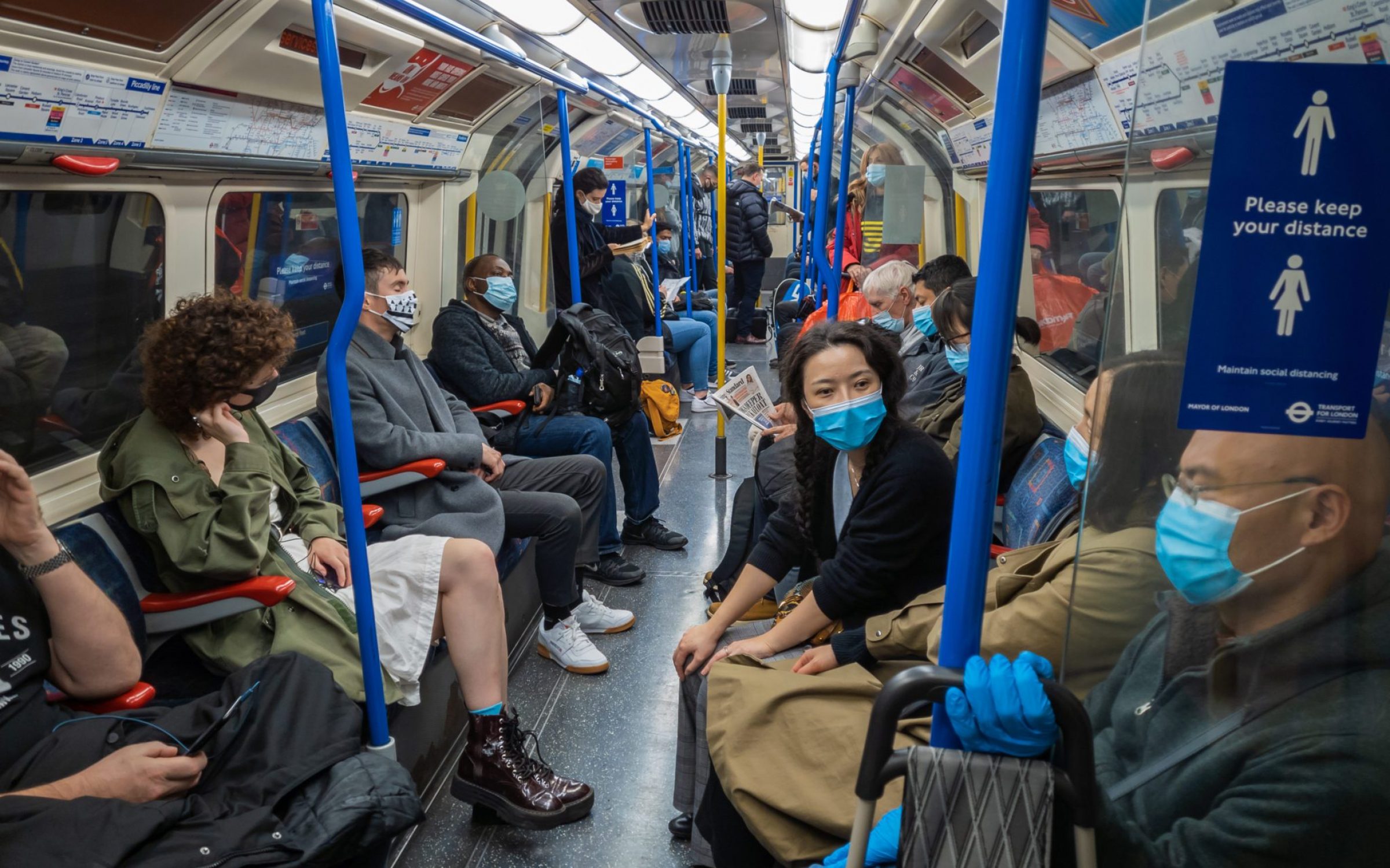 Commuters on busy tube with masks on in London
