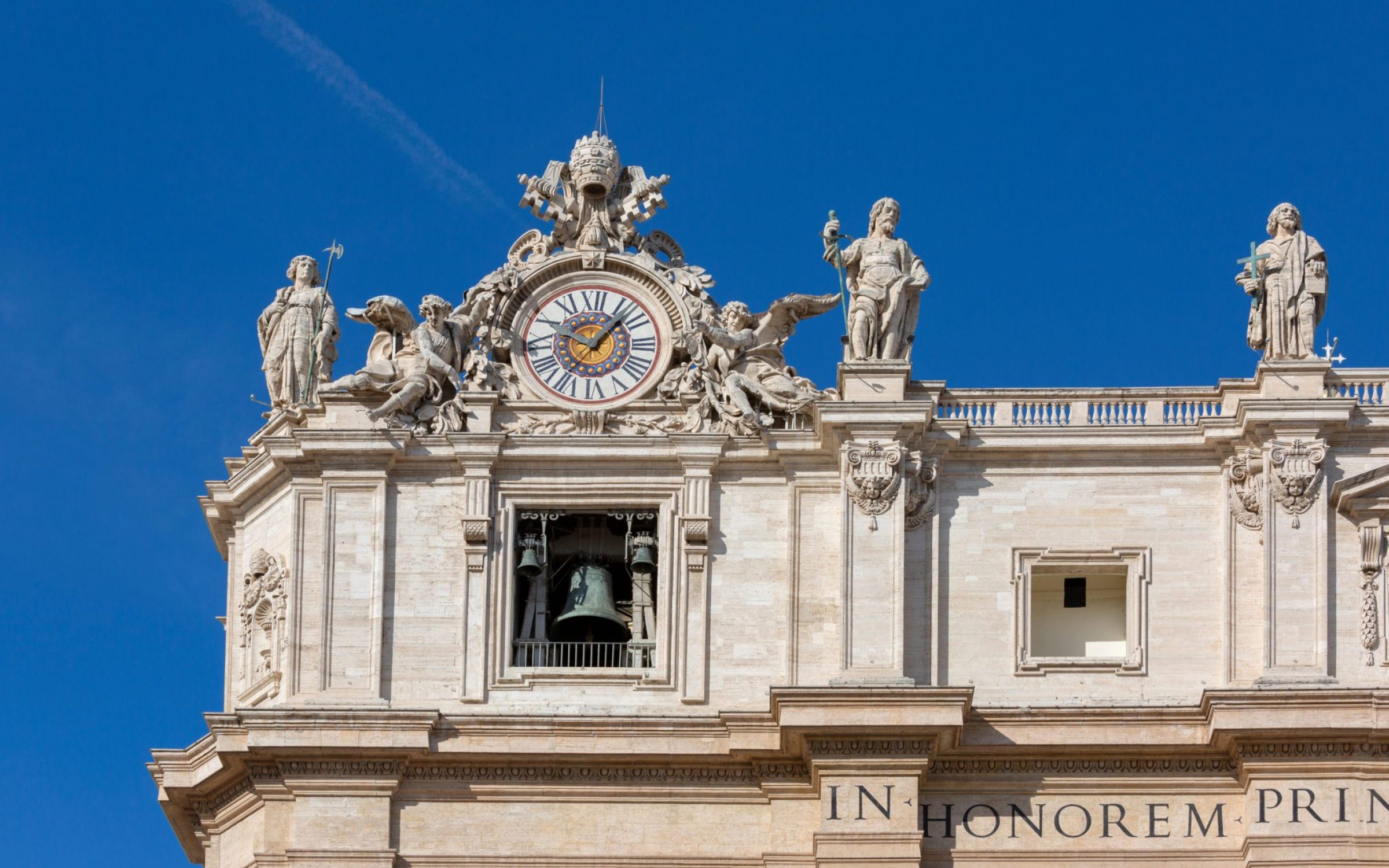 Facade of Saint Peter's Basilica with Bell Gate on a background of blue sky