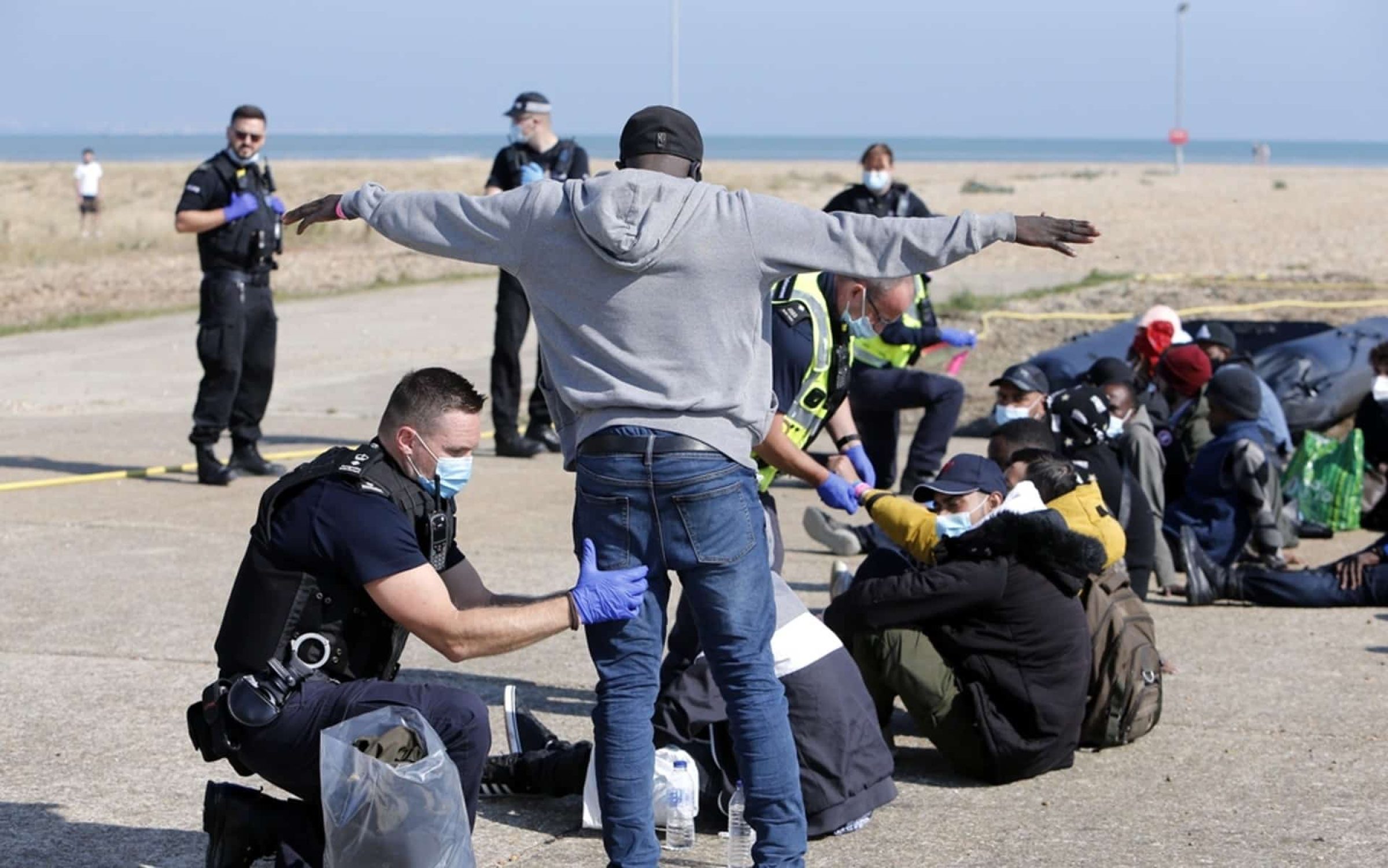 Dungeness, Kent, UK, May 6th 2022, Migrant being questioned and searched by Border Force officials on the beach at Dungeness after migrants crossed the English channel to the UK.