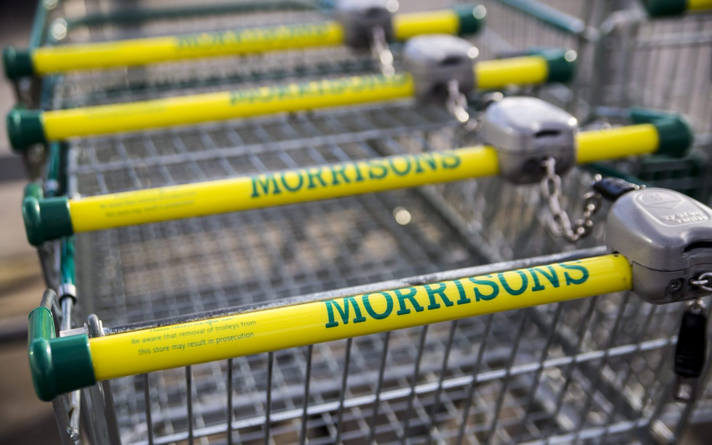 Morrisons supermarket trolley showing logo outside supermarket in Leeds, UK.